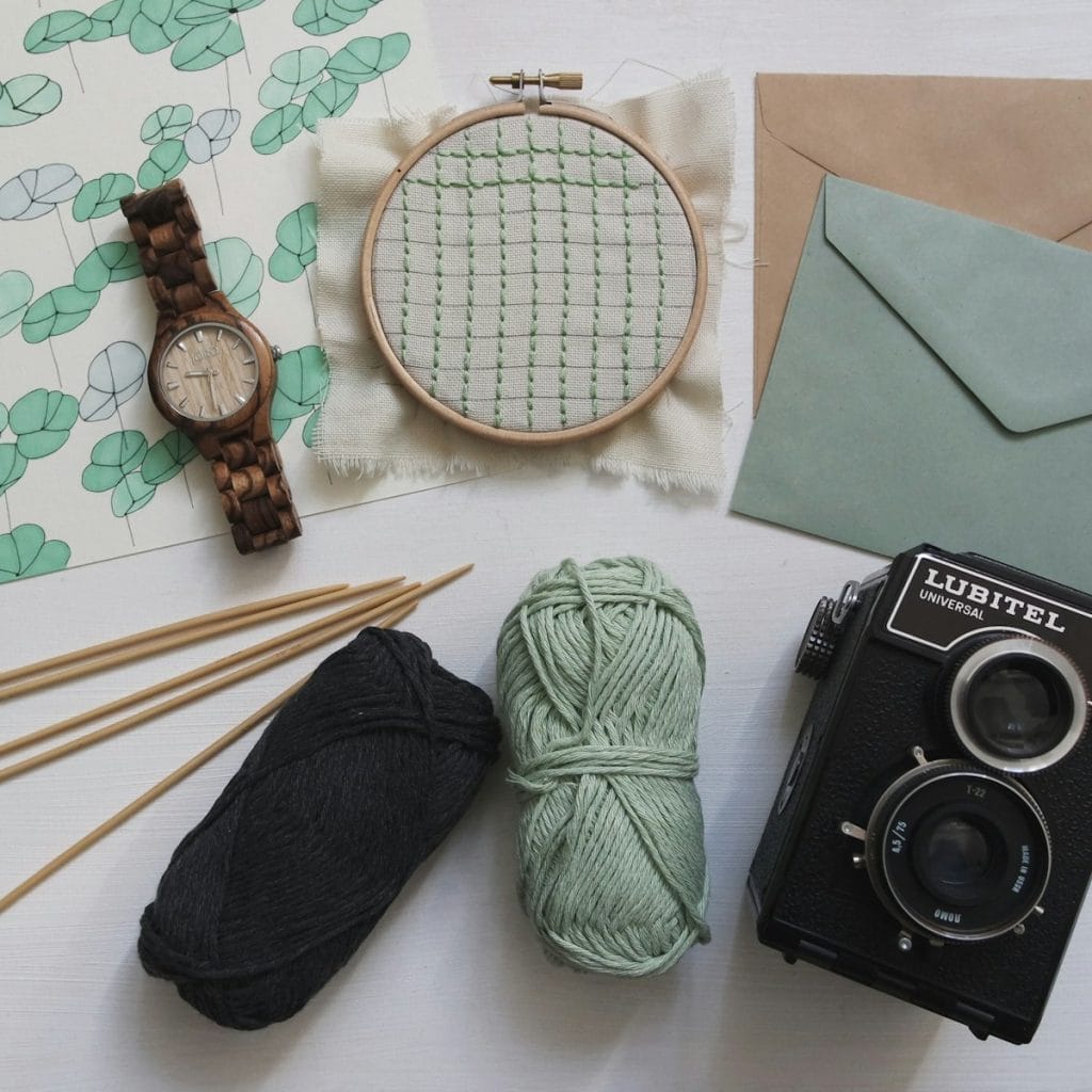 An early retirement hobby kit that includes knitting needles, yarn, and a camera.